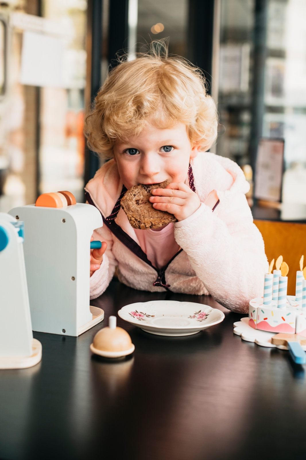 Kindje geniet van een koekje aan de speelhoek