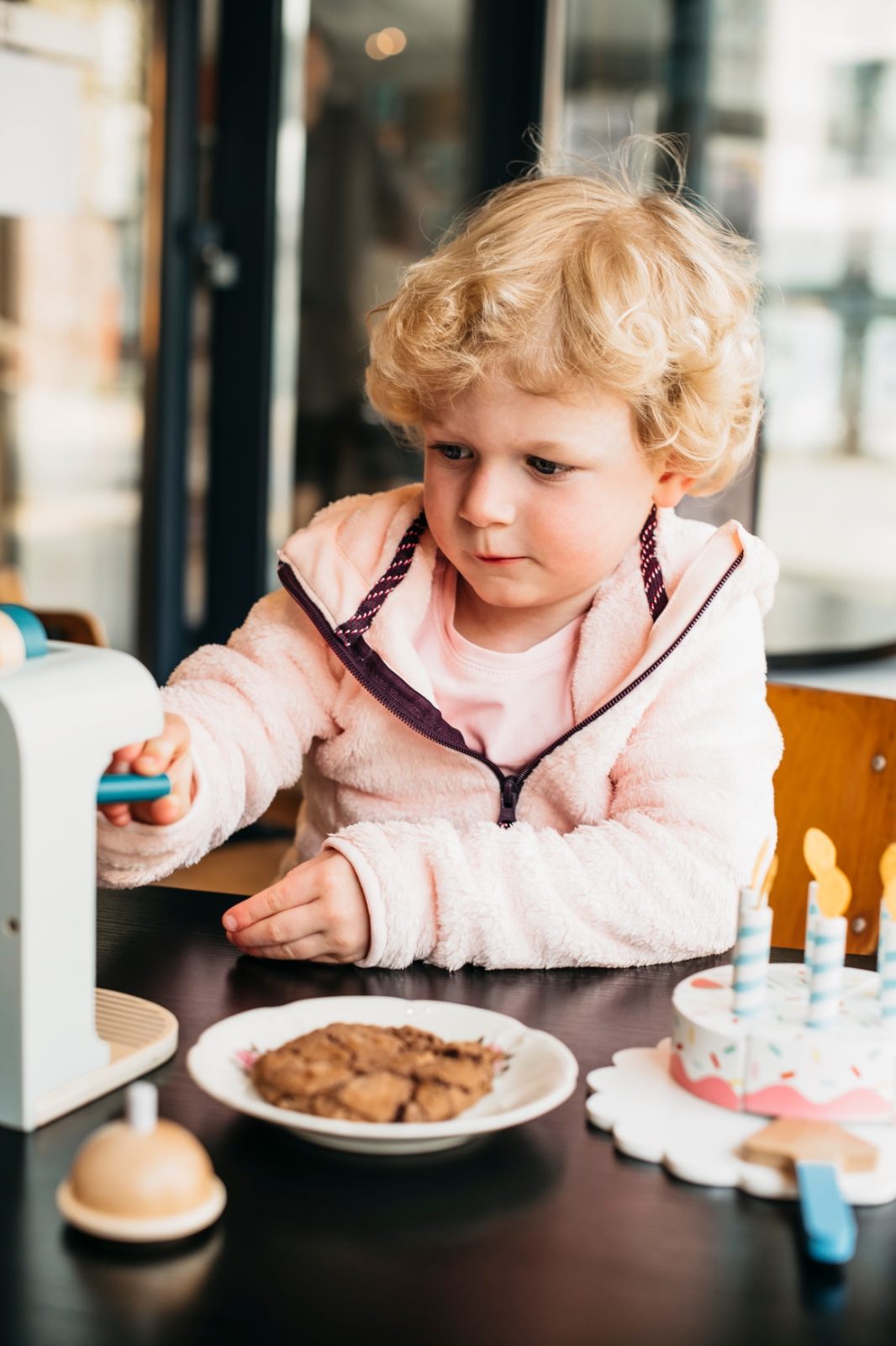 Kindje speelt aan tafel bij Madam Madeleine